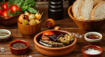 Παραδοσιακά ελληνικά vegan φαγητά όπως φασολάδα, γεμιστά και χόρτα σε τραπέζι - Traditional Greek table with vegan dishes: fasolada, gemista, olives and bread
