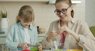 Mother and child preparing vegan food together in the kitchen