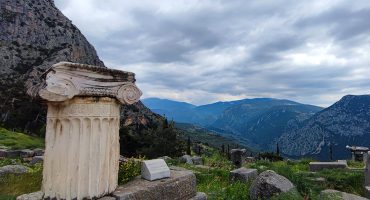 Ancient column in Delphi with mountain view towards Arachova, Greece