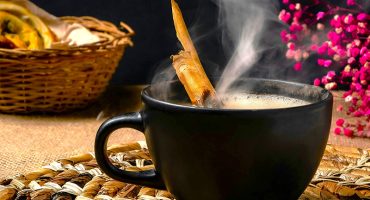 vegan hot chocolate with flowers and book on wooden table
