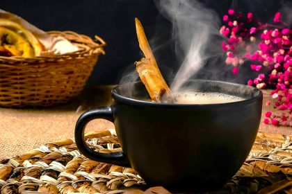 vegan hot chocolate with flowers and book on wooden table