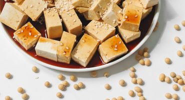 Block of tofu on a wooden board, introducing one of the world's most versatile plant-based foods
