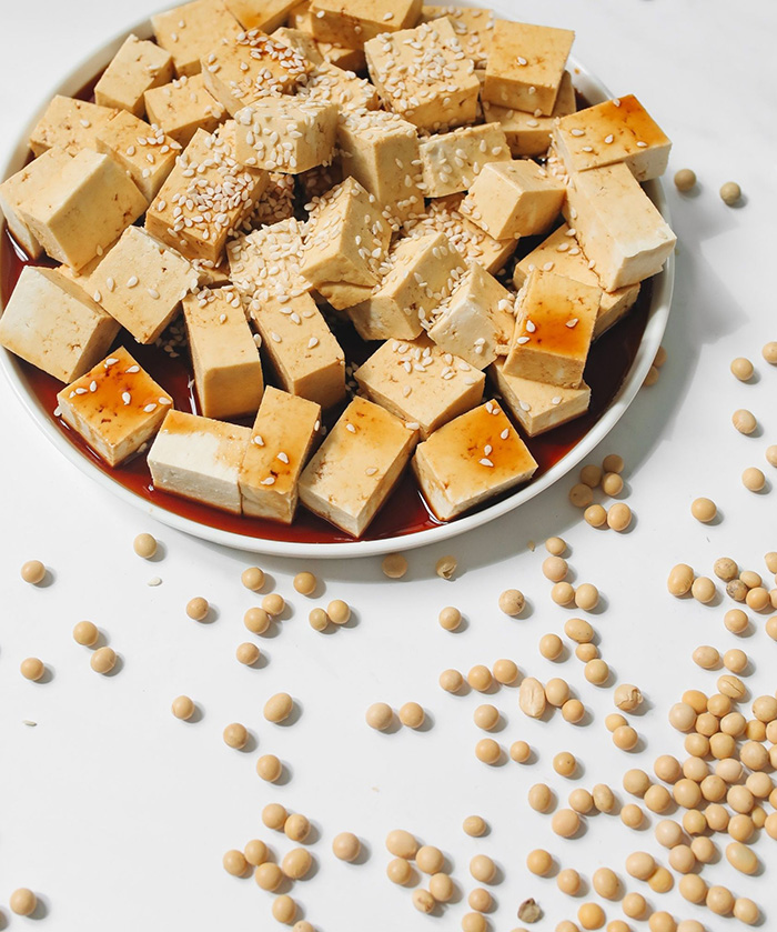 Block of tofu on a wooden board, introducing one of the world's most versatile plant-based foods